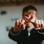Un garçon croisant les doigts